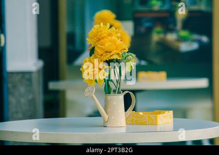 Vase, Töpfe, Gießkannen auf einem weißen Tisch Stockfoto