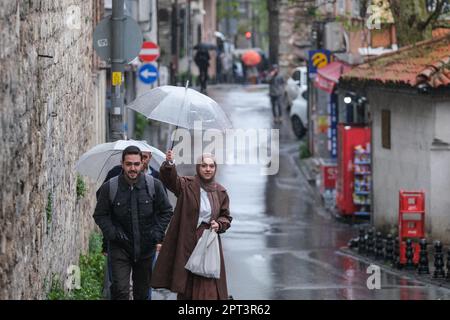 Istanbul, Türkei. 27. April 2023. Eine junge Dame versucht, ihren Liebhaber vor dem Regen in Istanbul zu schützen. Trotz des regnerischen und bewölkten Wetters zog die Dichte der Touristen im Stadtteil Süleymaniye von Istanbul, einer der beliebtesten Städte der Welt, Aufmerksamkeit auf sich. (Foto: Mine TOZ/SOPA Images/Sipa USA) Guthaben: SIPA USA/Alamy Live News Stockfoto