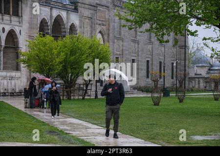 Istanbul, Türkei. 27. April 2023. Ein Mann hält einen Schirm, um ihn vor dem Regen im Garten der Süleymaniye-Moschee zu schützen. Trotz des regnerischen und bewölkten Wetters zog die Dichte der Touristen im Stadtteil Süleymaniye von Istanbul, einer der beliebtesten Städte der Welt, Aufmerksamkeit auf sich. (Foto: Mine TOZ/SOPA Images/Sipa USA) Guthaben: SIPA USA/Alamy Live News Stockfoto