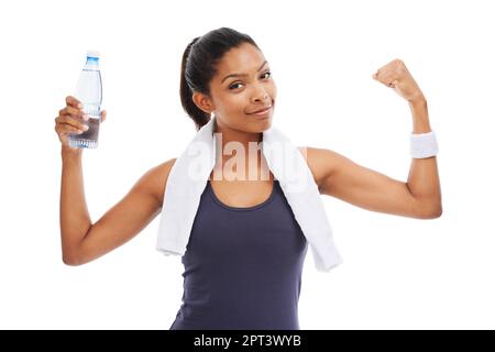 Ihr Fitnessprogramm ist ein Erfolg. Eine junge Frau, die eine Flasche Wasser in der Hand hält und nach einem anregenden Workout ihren Bizeps biegt Stockfoto