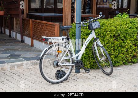 Tala, Paphos District, Zypern - 27. März 2023 - Weißes Elektrofahrrad an einer Restaurantfassade Stockfoto