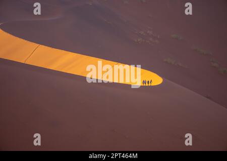 Touristen klettern auf Sanddünen, Sossusvlei, Namib-Wüste, Namib-Naukluft Park, Namibia Stockfoto