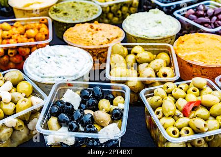 Oliven in Kunststoffkisten, die im Geschäft zum Verkauf angeboten werden. Stockfoto