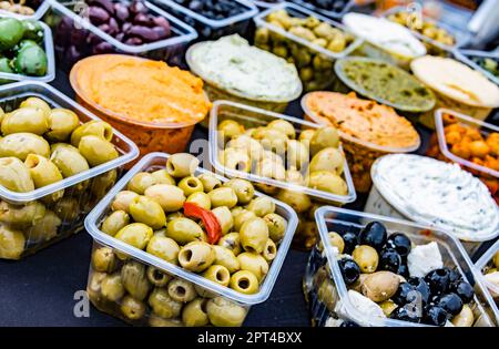 Oliven in Kunststoffkisten, die im Geschäft zum Verkauf angeboten werden. Stockfoto