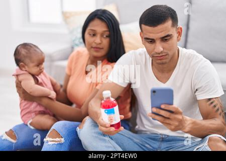Hispanische Familie, die Telemedizin zu Hause auf dem Boden hat Stockfoto