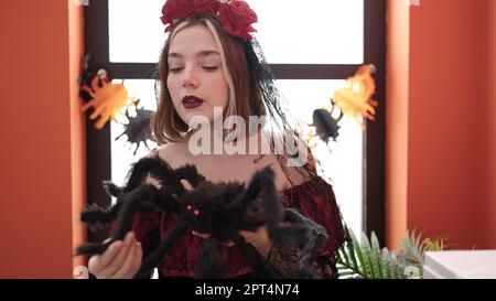 Eine junge blonde Frau, die zu Hause ein katrina-Kostüm trägt, um die halloween-Party zu dekorieren Stockfoto