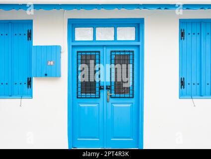 Omodos, Limassol District, Zypern, 24. März 2023 - traditionelle weiße Fassade mit blauen Fenstern und Türen Stockfoto