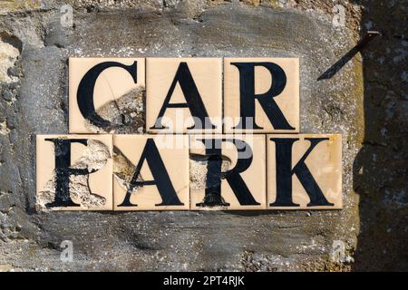 Parkplatz, Parkschild, Keramik, Fliesen, Schild, Altes Schild, gerissene, zerbrochene Fliesen, Buchstaben, öffentliches Schild, An der Wand montiert, Information, Höflichkeitsschild. Stockfoto