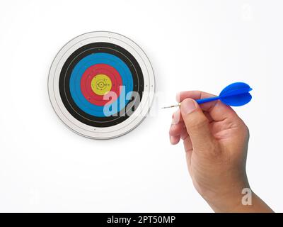 Die menschliche Hand wirft die Zielscheibe des Darts auf das Darts-Brett. Die Hand eines Mannes wirft einen Pfeil auf das Ziel Stockfoto