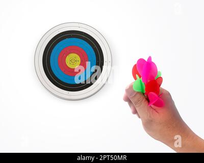 Die menschliche Hand wirft die Zielscheibe des Darts auf das Darts-Brett. Die Hand eines Mannes wirft einen Pfeil auf das Ziel Stockfoto