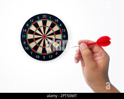 Die menschliche Hand wirft die Zielscheibe des Darts auf das Darts-Brett. Die Hand eines Mannes wirft einen Pfeil auf das Ziel Stockfoto