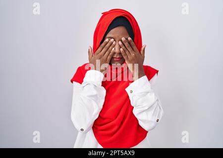 Junge arabische Frau trägt einen traditionellen islamischen Hidschab-Schal und reibt die Augen für Müdigkeit und Kopfschmerzen, Schläfrigkeit und müden Ausdruck. Sehstörungen Stockfoto