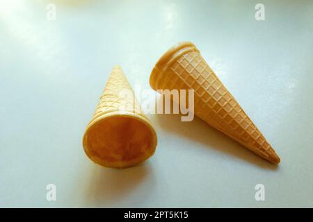 Leere krümelige Waffeln für Eis auf einer weißen Arbeitsfläche Stockfoto