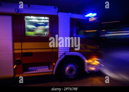 Dresden, Deutschland. 27. April 2023. Eine Feuerwehr trifft am Brandort in einer Wäscherei im Bezirk Pieschen ein. (Aufnahme mit langer Belichtungszeit) Robert Michael/dpa/Alamy Live News Stockfoto