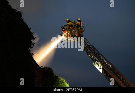 Dresden, Deutschland. 27. April 2023. Feuerwehrleute löschen einen Brand in einer Wäscherei im Bezirk Pieschen über eine Luftleiter. Kredit: Robert Michael/dpa/Alamy Live News Stockfoto