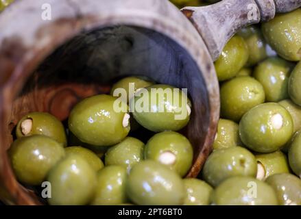 Gefüllte grüne Oliven in einer alten Holzschüssel Stockfoto