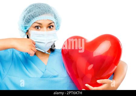 So wächst dein Herz doppelt so groß. Eine Krankenschwester, die einen herzförmigen Ballon hält, bereit, ihn vor einem Studiohintergrund zu injizieren Stockfoto
