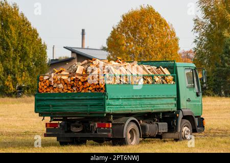 Kipplaster mit einer Leiche voller Brennholz, bereit für die Lieferung. Vorbereitung für die kalte Jahreszeit. Stockfoto