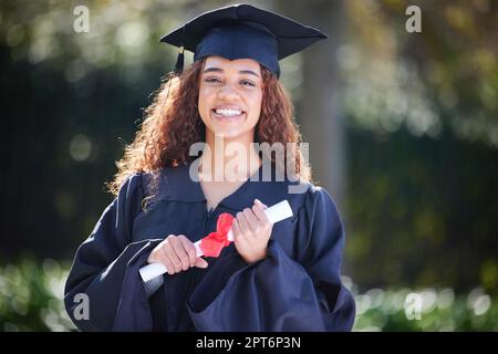 Harte Arbeit hat zu diesem freudigen Anlass geführt. Porträt einer jungen Frau mit ihrem Diplom am Abschlusstag Stockfoto