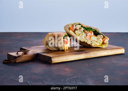 Fladenbrot gefüllt mit Hähnchen, Tomaten und Omelette Stockfoto