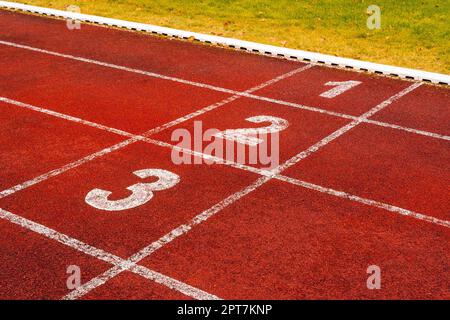 Beginne mit Zahlen auf der Laufbahn oder der Sportlerbahn im Stadion. Laufstrecke ist eine gummierte künstliche Lauffläche für Laufstrecke und Feld A. Stockfoto