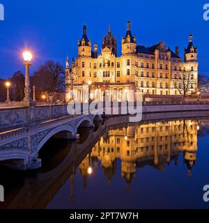 Beleuchtetes Schloss Schwerin mit der Schlossbrücke zur Schlossinsel am Abend, Schwerin, Mecklenburg-Vorpommern, Deutschland Stockfoto