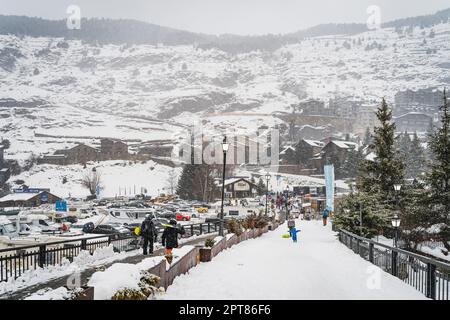 El Tarter, Andorra, Jan 2020 Personen, Familien mit Ski- und Snowboardausrüstung Wandern auf dem Hauptparkplatz mit Skiliften, Pyrenäen Stockfoto