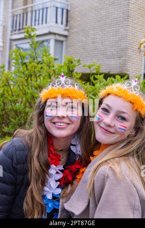 Europa, Niederlande, Utrecht, Maarssen. 27. April 2022. Zwei junge Frauen nehmen an den Feierlichkeiten zum Königstag in Maarssen Teil. Stockfoto