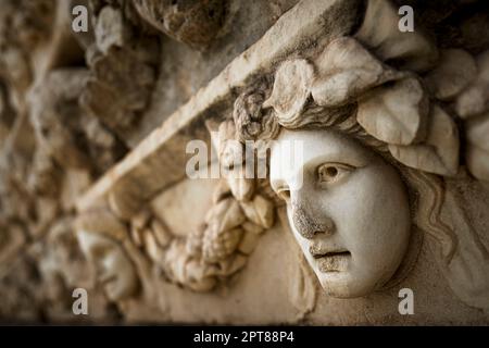 Friesen auf dem Tiberius-Portikus, in dem verschiedene Götter, Göttinnen und Porträtköpfe in Aphrodisias, Aydin, Türkei, abgebildet sind Stockfoto