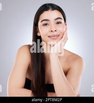 Jeder will das Leuchten, das sie hat. Studioporträt einer attraktiven jungen Frau, die vor grauem Hintergrund posiert Stockfoto