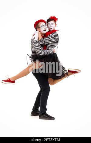 Lächelnd mimen in gestreiften Hemden. Mann und Frau tanzen auf weißem Hintergrund Stockfoto