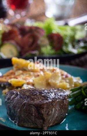 Steak mit Bohnen und Kartoffelgratin Stockfoto