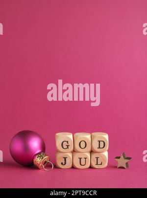 Kleine Holzblöcke mit der Aufschrift God Jul, Scandinavian Merry Christmas, lila Hintergrund, minimalistische Holzweihnachtsdekoration Stockfoto