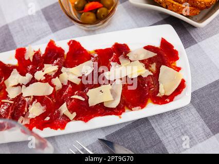 Teller mit zartem rohem Kalbfleisch-Carpaccio mit Käse Stockfoto