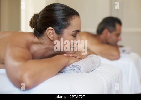 Ein reifes Paar, das sich auf Massageliegen ausruht Stockfoto