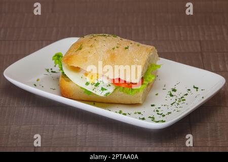Ciabatta Panini Sandwich mit Huhn und Tomate. Sandwich gefüllt mit Wurst, Ei und Tomate. Stockfoto
