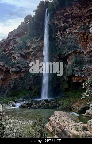 Ein großer Wasserfall an einem sonnigen TagVorderansicht, Langzeitbelichtung, Wasser mit Seideneffekt. Braut springt Stockfoto