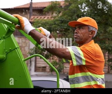 Er hält unsere Straßen sauber. Ein männlicher Arbeiter am Mülltag Stockfoto