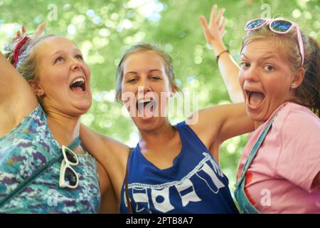 So. Viel. Aufregung. Abgeschnittenes Porträt einer Gruppe von Freundinnen, die Spaß auf einem Outdoor-Festival haben Stockfoto