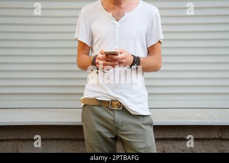 Ein Mann mit Handy in der Hand. Abhängigkeit von Technologie, sozialen Netzwerken und Kommunikation Stockfoto