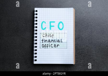 Notizbuch mit Abkürzung CFO (Chief Financial Officer) auf grauem Steinhintergrund, Draufsicht Stockfoto