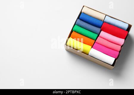 Box mit verschiedenen bunten Socken auf hellem Hintergrund, über der Ansicht. Platz für Text Stockfoto