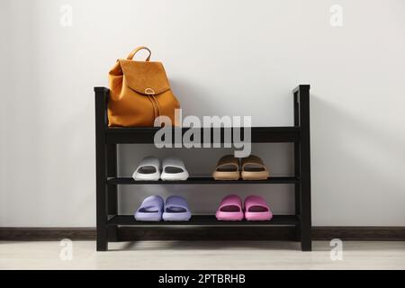 Aufbewahrungsbank mit Paar Gummipantoffeln im Innenbereich Stockfoto