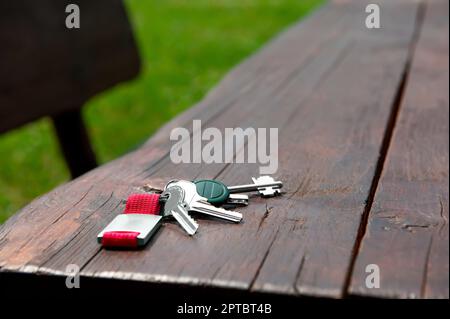 Schlüssel vergessen auf Holzbank draußen. Verloren und gefunden Stockfoto