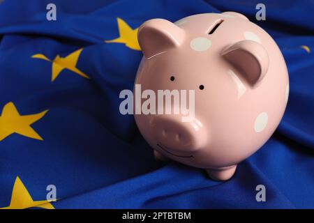 Rosa Sparschwein auf EU-Flagge, Nahaufnahme Stockfoto