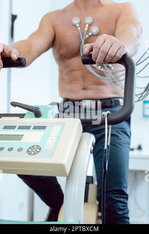 Patient während des Belastungs-EKGs auf einem stationären Fahrrad Stockfoto