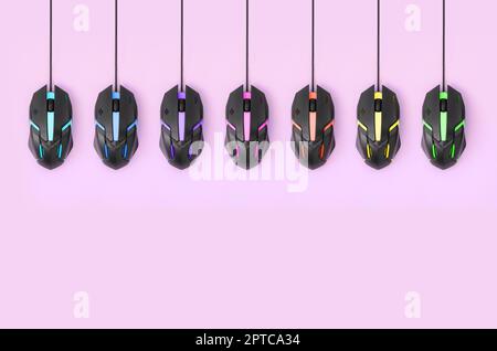 Mehrere Computer Mäuse hängen an ein Pastell rosa Hintergrund. Das Konzept der kooperativen Computer video Spiele, die Verwendung von Auto-Clicker und Zahlen-pro-Klicken pla Stockfoto