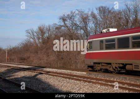 Bild eines Zuges, der die Stadt Banatsko novo selo, Serbien, durchquert und von den nationalen Personenbahnen Serbiens betrieben wird. Stockfoto