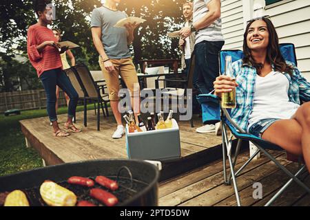 Grillsaison in vollem Gange. Eine Gruppe von Freunden, die ein Barbecue im Hof veranstalten. Stockfoto