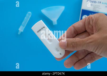 Herstellung des Coronavirus-Covid-19-Antigen-Tests mit positivem Ergebnis auf weißem Hintergrund. Stockfoto